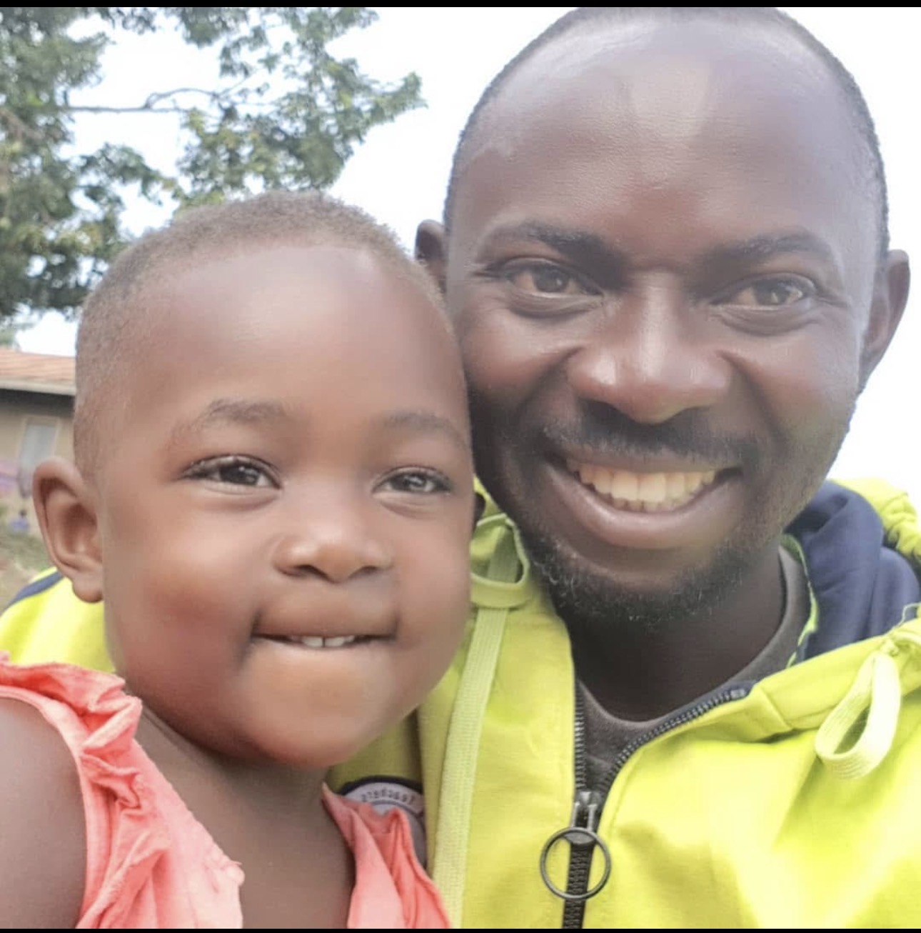 Coach smiling with a young child from the community